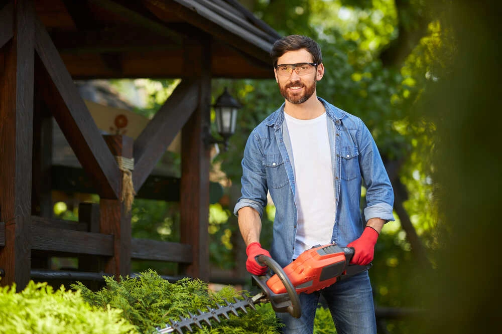 Landscaper with hedge trimmer